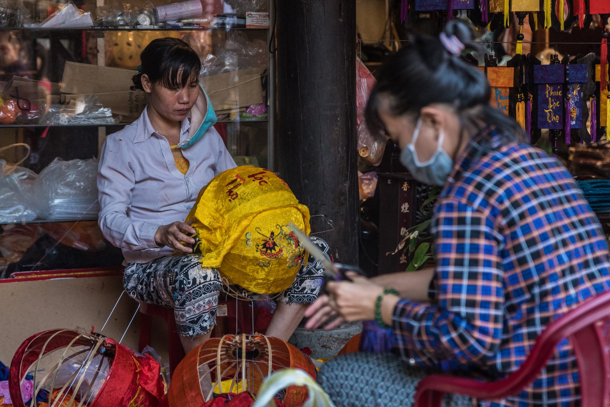 two vietnamese women making lanterns in Hoi An, Vietnam