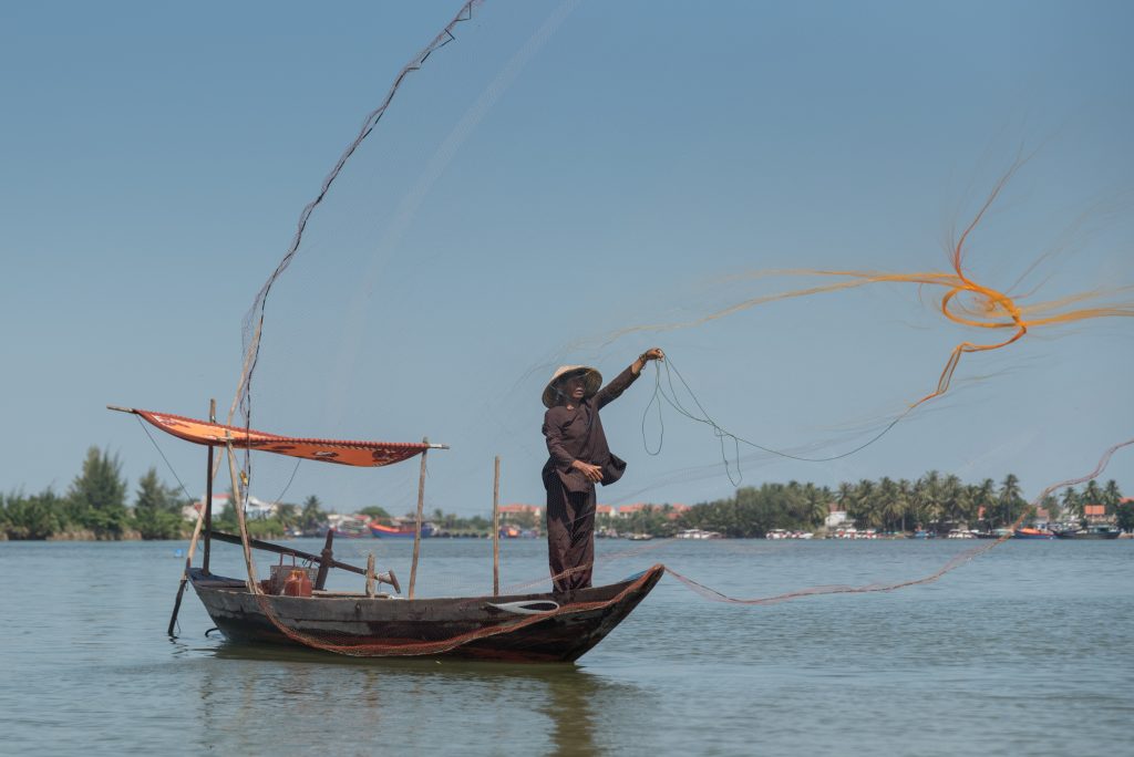 Fisherman throwing a net in the traditional vietnamese way